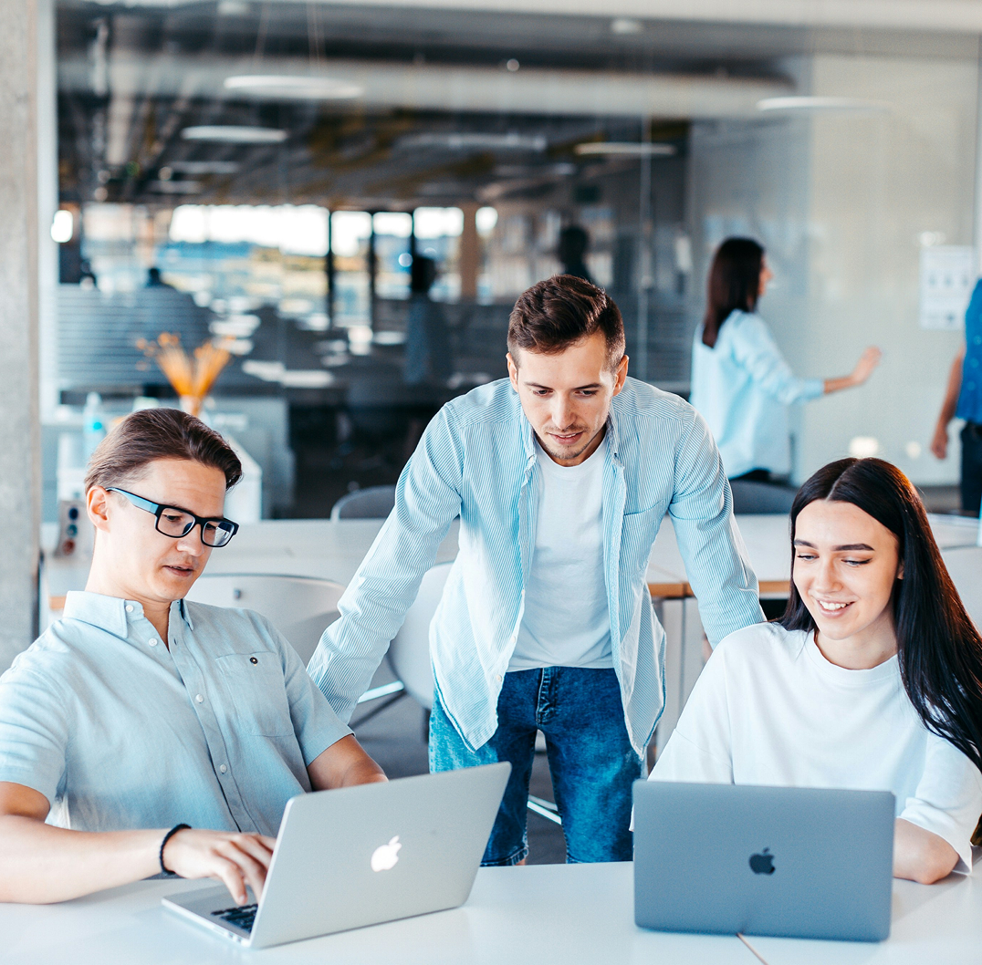 Colleagues collaborating on laptops in an office